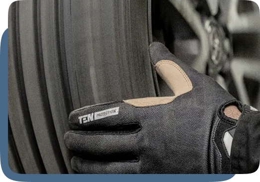 Gloved hand inspecting a tire